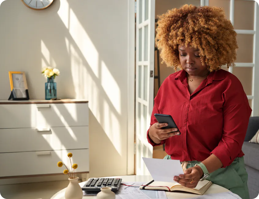 A business owner checking her phone and payment records